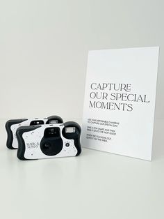 two cameras sitting next to each other in front of a white sign that says capture our special moments