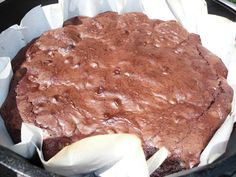 a chocolate cake sitting on top of a pan covered in wax paper and napkins