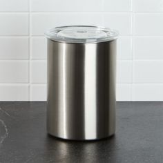 a stainless steel trash can sitting on top of a counter