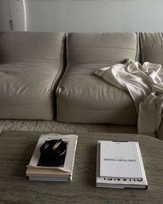 a living room with a couch, coffee table and book on the floor next to it