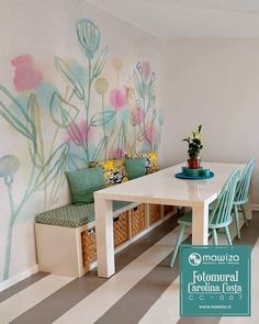 a room with a table, bench and flowers painted on the wall behind it is a striped floor