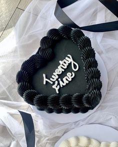 a heart shaped cake sitting on top of a table next to a plate of cookies