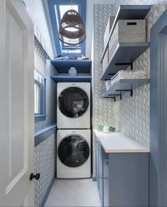 a washer and dryer in a small laundry room with blue accents on the walls