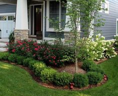 a house with flowers and trees in the front yard