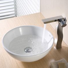 a white bowl sink sitting on top of a wooden counter