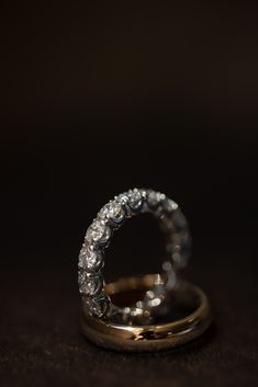 A diamond-encrusted ring is propped up on a plain gold band against a dark background. Editorial Wedding, Classic Gold, Dark Background, Minimalist Rings, Love Symbols, Gold Band, Dark Backgrounds, Gold Bands, Wedding Bands