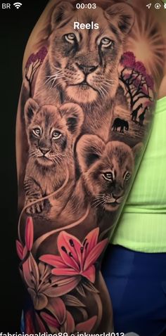 a woman's arm with an image of lions and flowers on it, in the background