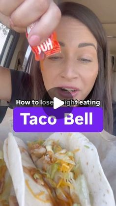 a woman eating taco bell in the back seat of a car