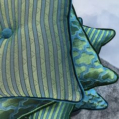 two green and blue pillows sitting next to each other