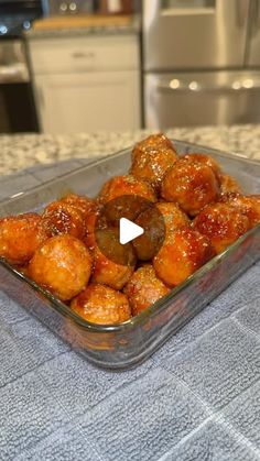 a glass bowl filled with food on top of a counter next to a stovetop