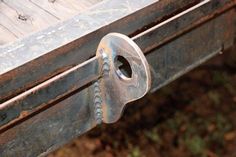 an old wooden bench with rusted metal latch on the top and bottom part missing