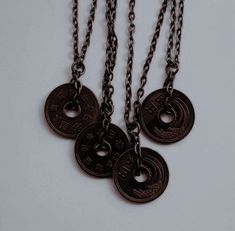 three coin necklaces are hanging from chains