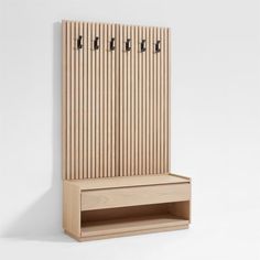 a wooden bench with two hooks on the back and an open shelf below it for storage