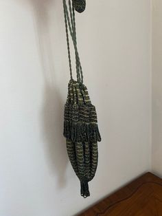 a pair of gloves hanging from a hook on a wall next to a wooden floor