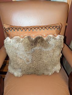 a brown leather chair with a pillow on it