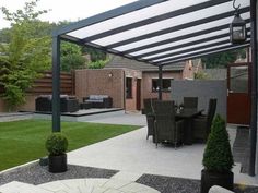 an outdoor dining area with grass and potted plants