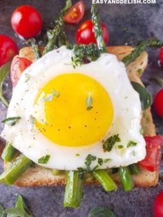 an egg on toast with asparagus and tomatoes