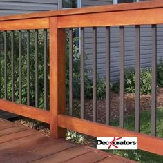 a wooden deck with metal railings in front of a house