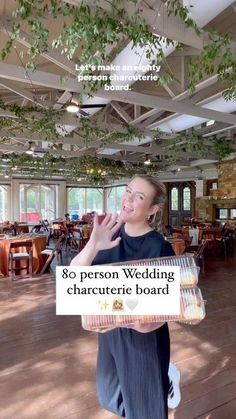 a woman holding a sign that says, 80 person wedding charure board in front of her