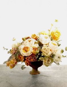 a vase filled with lots of flowers on top of a table