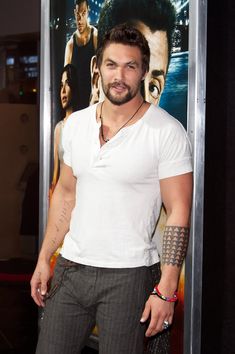 a man with tattoos standing in front of a poster for the movie's avatar