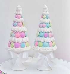 two tiered cakes decorated with colorful confetti and white frosting on top of each other