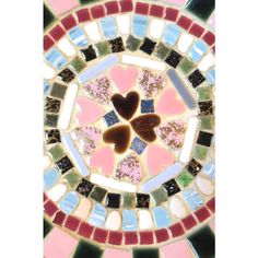 a heart shaped glass plate with multicolored tiles in the center and hearts on it