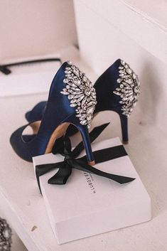 two pairs of blue high heeled shoes with bows on top of a white box