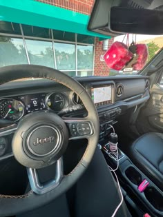 the interior of a car with an electronic display and steering wheel controls, including two red balls