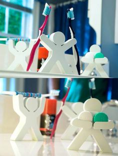 toothbrush holders made out of paper people holding toothbrushes in front of a mirror