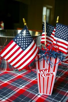 an american flag centerpiece is sitting on a table with red, white and blue decorations