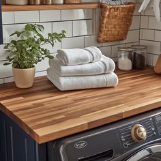 towels are stacked on top of a washer in the kitchen