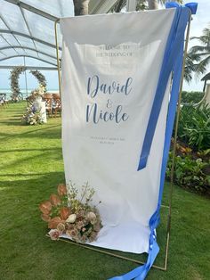 a white and blue sign sitting on top of a lush green field