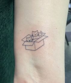 a small tattoo of three cats in a box