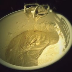 a mixing bowl with yellow batter in it