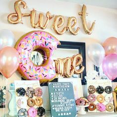 a table topped with donuts and balloons