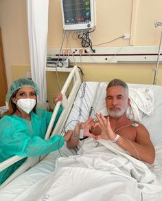 a man and woman in hospital gowns sitting on a bed with an oxygen tube