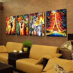 a living room with couches and paintings on the wall