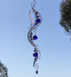 a wind chime hanging from the side of a tree with blue glass beads on it