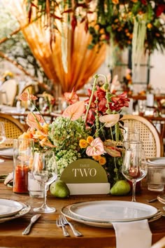 the table is set with flowers, fruit and wine glasses for an elegant wedding reception