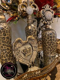 two ornate vases with hearts on them are sitting next to each other in front of a floral arrangement