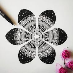 a drawing of a flower with black and white designs on it next to some pink flowers