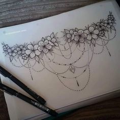 a drawing of flowers and beads on a sheet of paper with a marker next to it