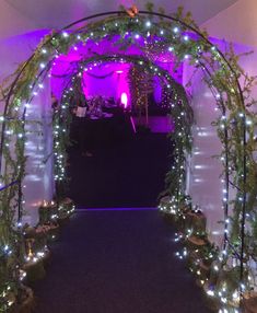 an archway decorated with lights and greenery