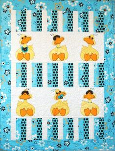 a blue and white quilt with yellow rubber ducks on it's sides, in front of a flowered background