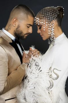 a man and woman are dressed up for a fashion photo shoot with feathers on their head