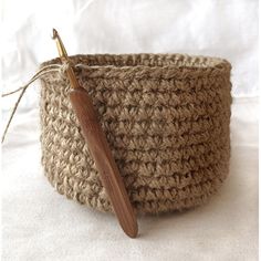 a crocheted basket with a wooden handle