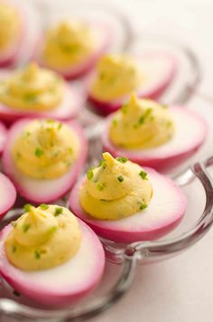 small deviled eggs are arranged on a glass plate