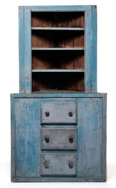 an old blue cabinet with two drawers and one door open to reveal the bottom drawer