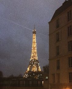 the eiffel tower is lit up at night